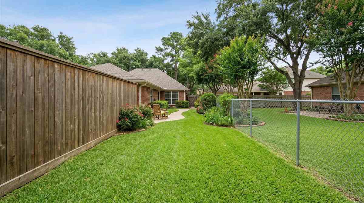 Wood privacy fence and chain link fence side by side in a Houston Texas backyard