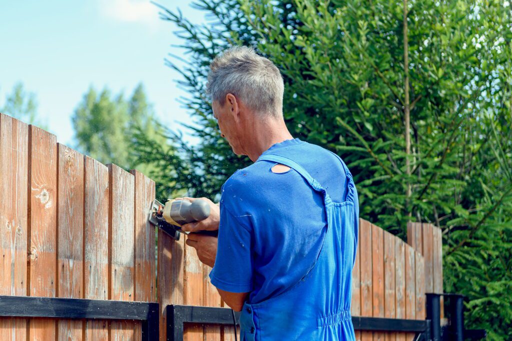 Close Up Process Cutting Fence With Jigsaw Man Aligns Fence With Jig Saw Country Plot - Griffin Fence Houston TX